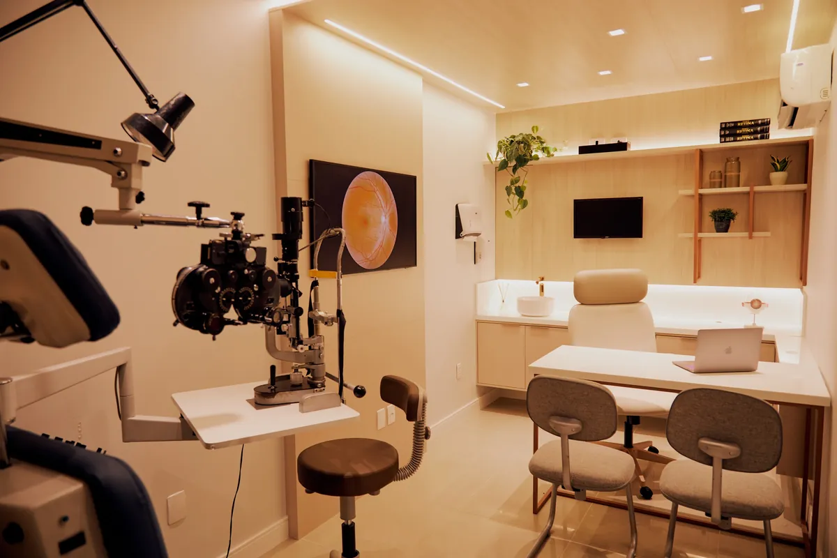 Sala de exame do consultório da OlharPar, com lâmpada de fenda, equipamentos de avaliação e mesa de consulta ao fundo.