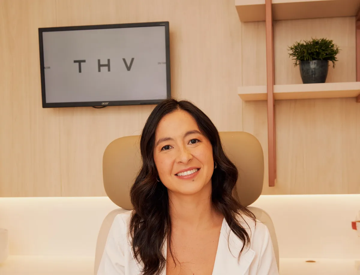 Dra. Nina Konichi sorrindo, sentada em seu consultório.